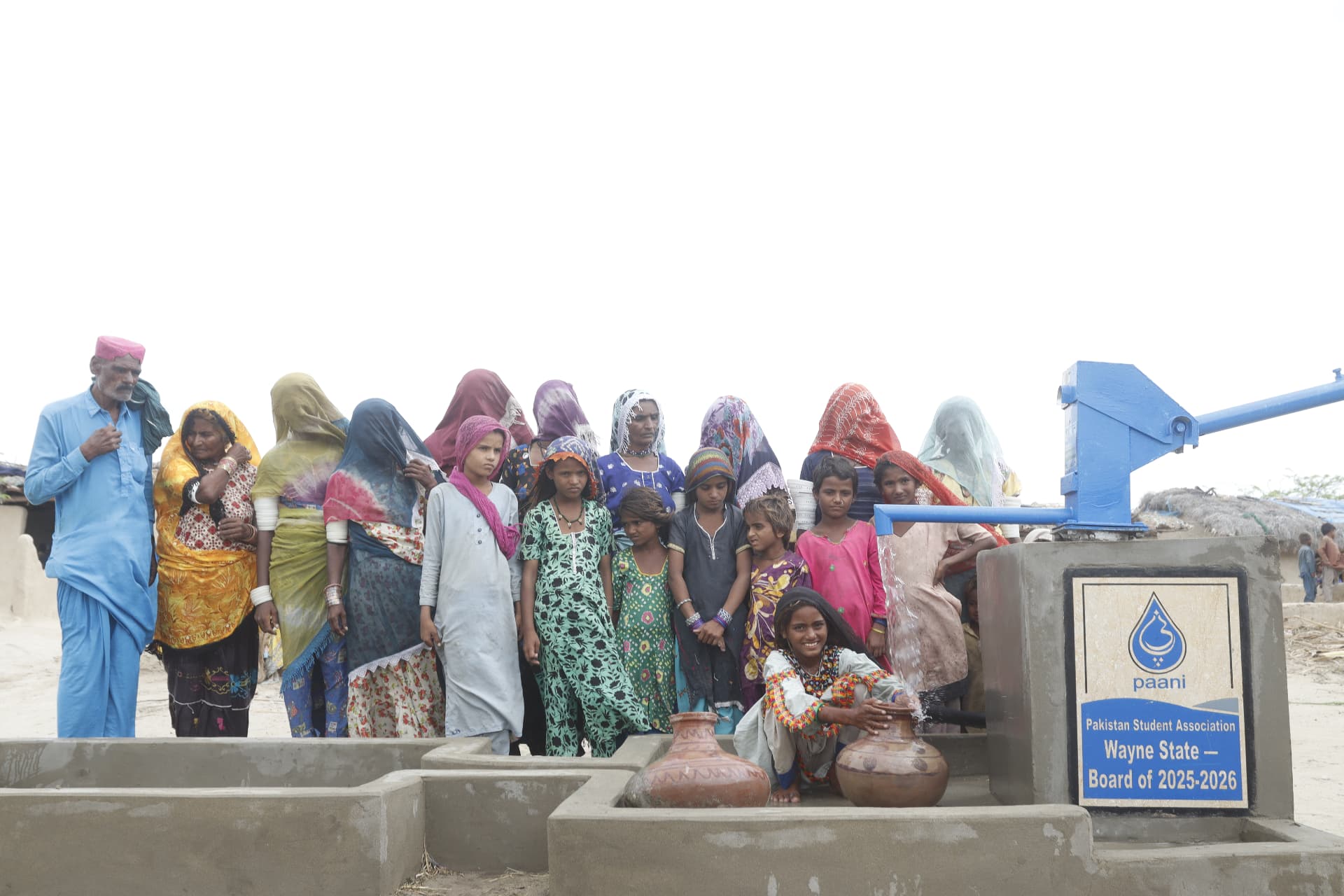 Families of the village standing beside the completed well